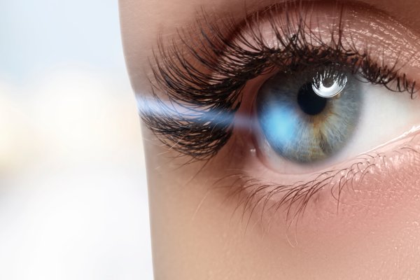 Close-up of an eye with laser beam, illustrating advanced laser eye surgery