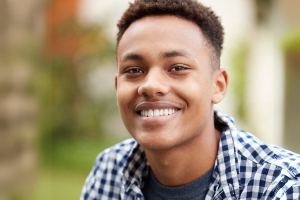 Young man smiling outdoors, representing successful keratoconus management with cross-linking